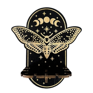 Detail of black wooden wall shelf featuring moth and moon phase carvings with storage shelf