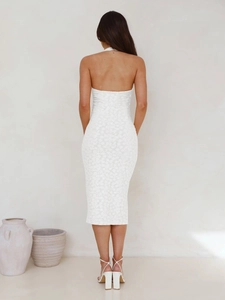 Detail of white backless lace maxi dress with halter neck and slim fit silhouette