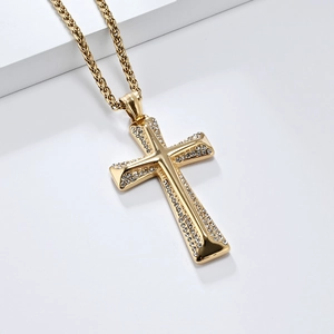 Macro shot of gold cross pendant with crystal inlay on twisted rope chain