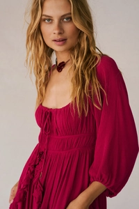 Detail of smocked waist and tie-up neckline on deep rose puff sleeve dress