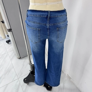 Detailed view of the back pockets and washed denim texture of women's stretch jeans