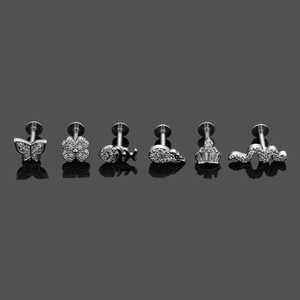 Detailed macro view of six silver stainless steel ear studs with zircon butterfly and crown