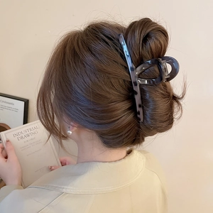 Detail of grey leopard print acrylic hair claw clip showing a strong metal spring on model