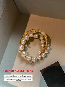 Detailed macro view of 24k gold-plated brooch with lustrous round pearls and zircons