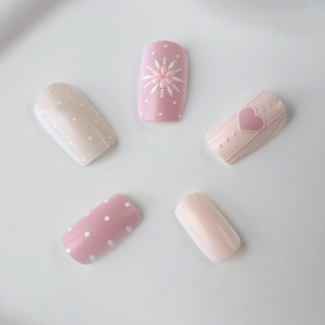 Unghie finte rosa con cuori e fiori e design a pois in forma ovale medio-lunga
