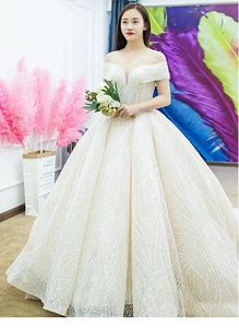 Macro detail of wave-patterned sequin embroidery on luxury off-shoulder bridal gown