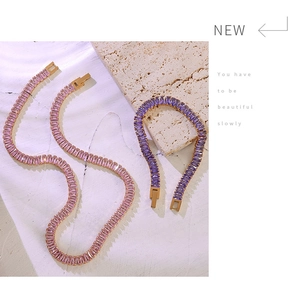 Detail of pink and purple crystal jewelry set featuring rectangular cut stones on gold base