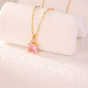 Macro shot of square pink zircon pendant on a delicate gold chain necklace detail
