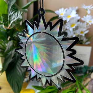 Close-up of sun-shaped holographic suncatcher pendant with prismatic light effect