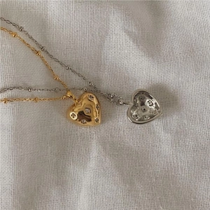 Close-up of 925 sterling silver heart necklaces with zircon stones in gold and silver