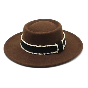 Close-up of brown wool felt hat with black ribbon and white beaded edge detail