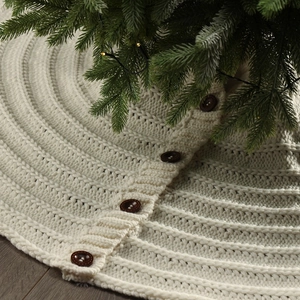 Close-up of cream knitted Christmas tree skirt with vintage brown buttons and textures