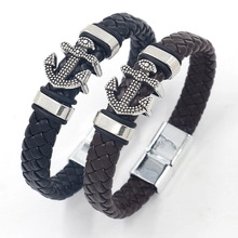 Detail of woven leather bracelets in black and brown with metal anchor charms and magnetic clasp