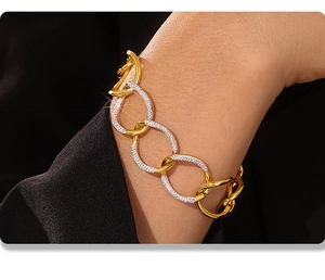 Macro shot of two-tone gold and silver chunky link chain bracelet with pavé rhinestones