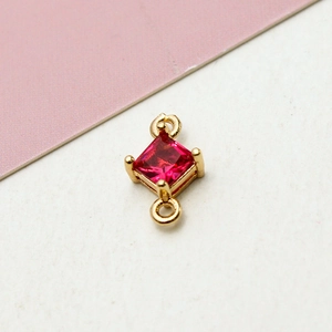Detailed view of square red gemstone link with gold setting for jewelry DIY