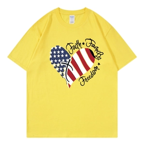 Flat lay of yellow cotton T-shirt featuring American flag heart and faith themed graphics