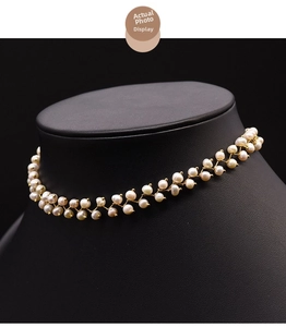 Detail of natural freshwater pearl choker with gold woven wire on a black mannequin