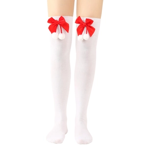 Detail of white over-the-knee socks featuring red bows and fluffy white pom-pom accents