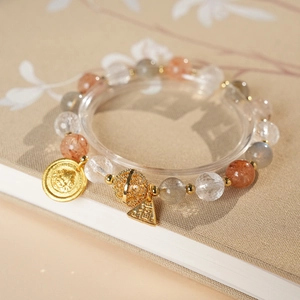 Macro shot of colorful gemstone bracelet with golden Fu character pendant and crystal beads