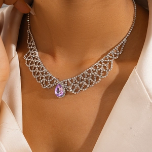 Close-up of a silver grid necklace with a purple waterdrop pendant on a female model