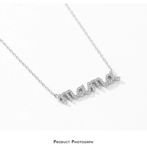 Macro shot of silver S925 sterling silver mama pendant with pavé cubic zirconia setting