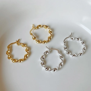 Close-up of gold and silver S925 sterling silver twisted rope hoop earrings