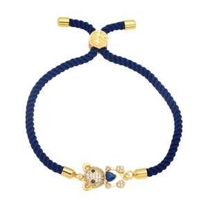 Detailed shot of dark blue woven rope bracelet with gold bear and blue heart gem