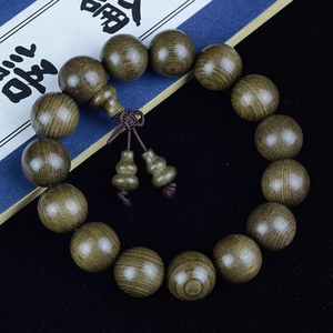 Detailed view of ebony wood beads with fine texture and carved double gourd pendants
