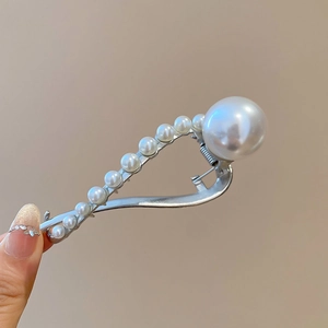 Detailed macro view of a silver-toned hair claw clip decorated with white pearls