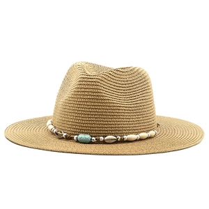 Detail of bohemian straw hat band featuring wooden beads, shells, and turquoise accents