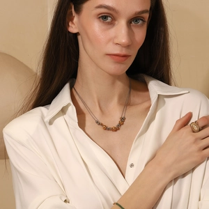 Detail view of 18K gold plated double-layered necklace with alternating metal beads