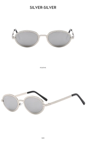 Detail view of oval silver metal sunglasses with textured frame and reflective lenses