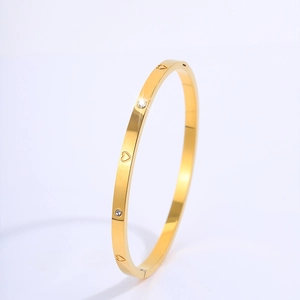 Detail of 18k gold plated stainless steel bangle with hollow hearts and zircon stones
