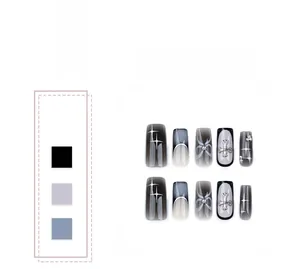 Detail of square black ombre press-on nails with silver crosses and bow designs