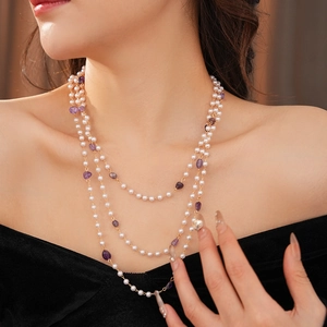 Detailed layered necklace featuring white pearls, purple amethysts, and golden chains