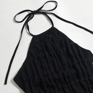 Detail of black halter top with layered lace ruffles and lightweight textured fabric
