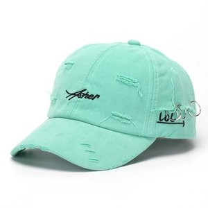 Close-up of mint green distressed baseball cap with metal rings and Asher embroidery