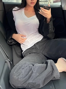 Close-up of white V-neck slim fit T-shirt paired with a black blazer in a car