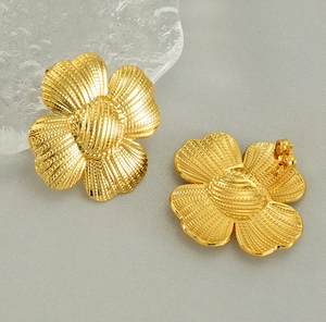 Gros plan détaillé des boucles d'oreilles tournesol dorées avec pétales texturés et fermoirs