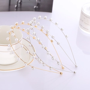 Elegant gold and silver hair hoops with pearls on a clean white surface