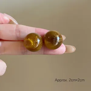 Detail of round resin geometric earrings in brown with gold shimmer, approx 2cm by 2cm