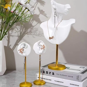 Modern white resin ear and bust jewelry display stands with gold metal rod accents