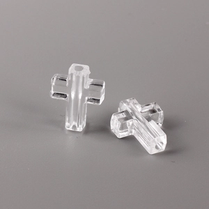 Macro shot of two transparent crystal cross beads with central holes for jewelry making