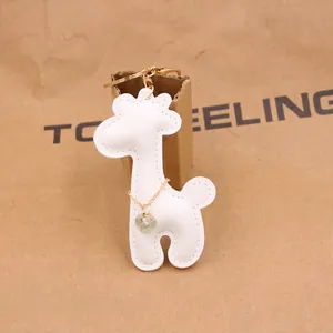 Detail of white PU leather giraffe keychain with gold chain and sparkling crystal charm
