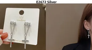 Detail of silver post tassel earrings featuring pearl accents and crystal cross pendants