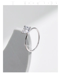 Détail macro d'une bague solitaire rectangulaire en argent S925 sur un support en pierre