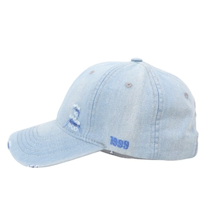 Detail of light blue denim baseball cap featuring vintage 1999 embroidery and distressed edges
