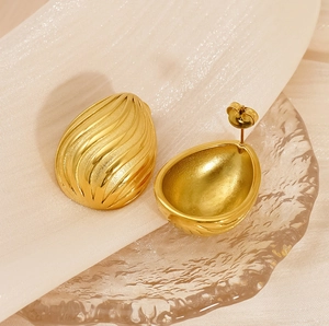 Detailed view of teardrop earrings with 18K gold plating and organic shell texture