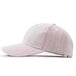 Détail du tissu texturé tie-dye rose et blanc sur une casquette de baseball tendance