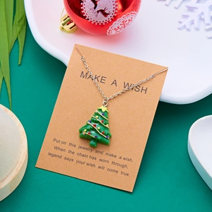 Nahaufnahme der grünen Weihnachtsbaum-Halskette auf brauner Make a Wish Geschenkkarte